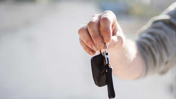 A hand that is passing on a car key.