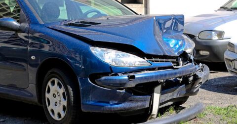 Blue car that has suffered bad front end accident damage