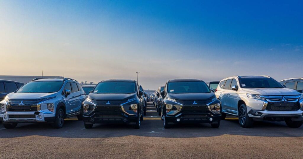 Lined up cars for sale in a huge parking lot.