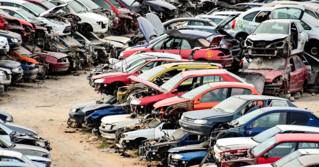 Piles of old junk cars in a yard.