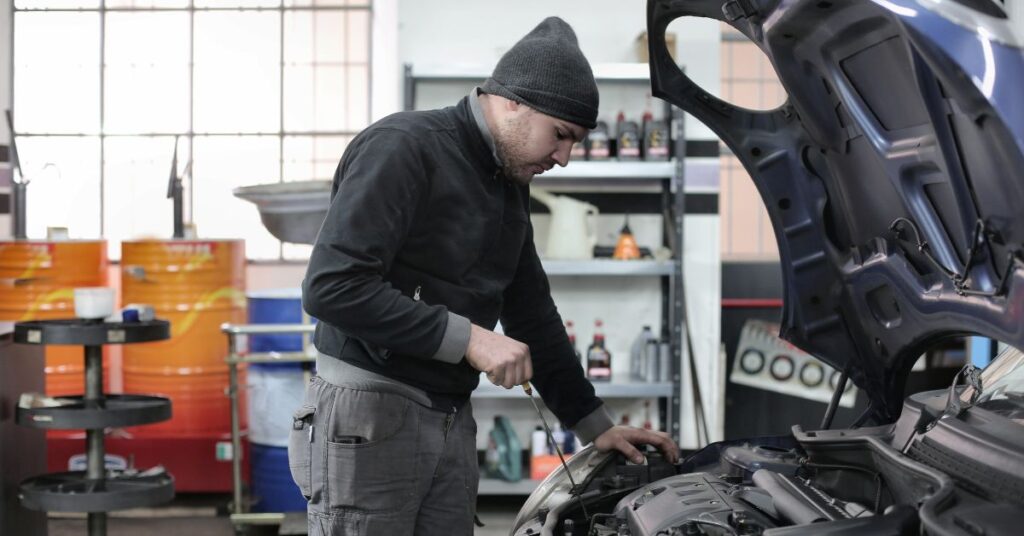 A mechanic performing a routine maintenance on a car engine.