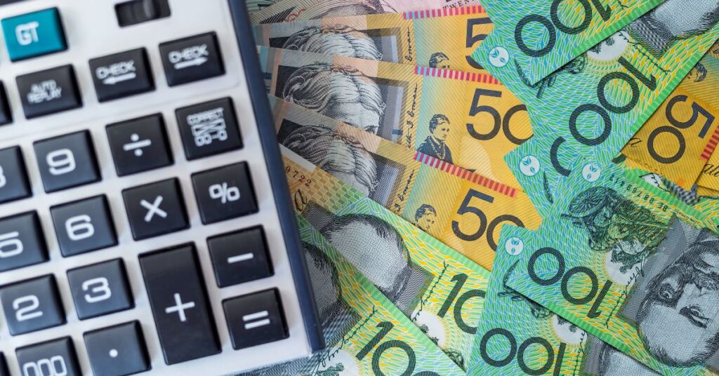 Calculator with colorful australian dollars on wooden table