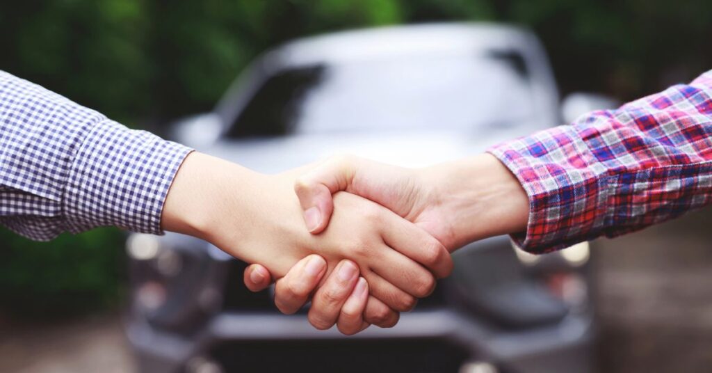 A person selling his car privately to a buyer.